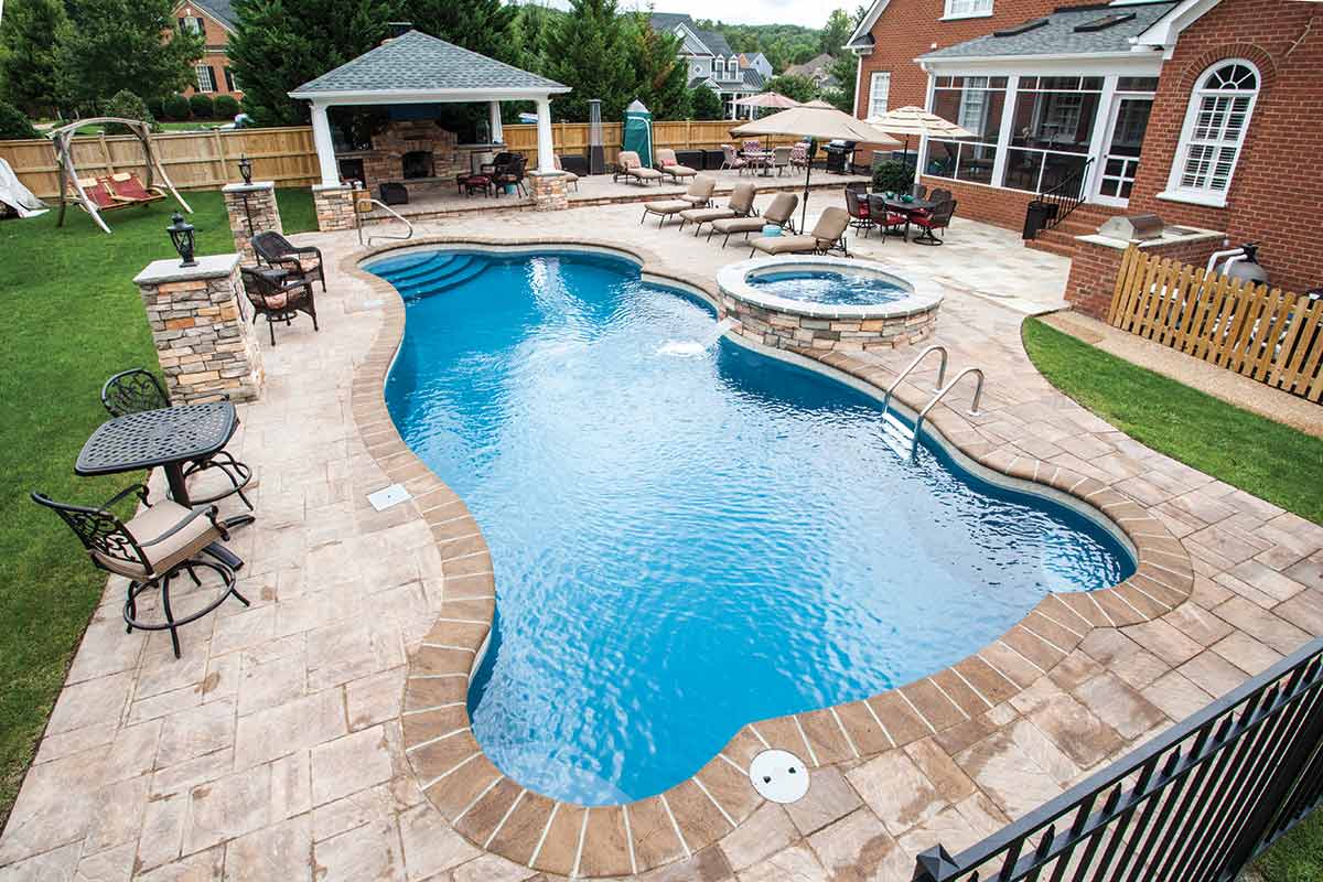 Backyard pool surrounded by chairs and tables